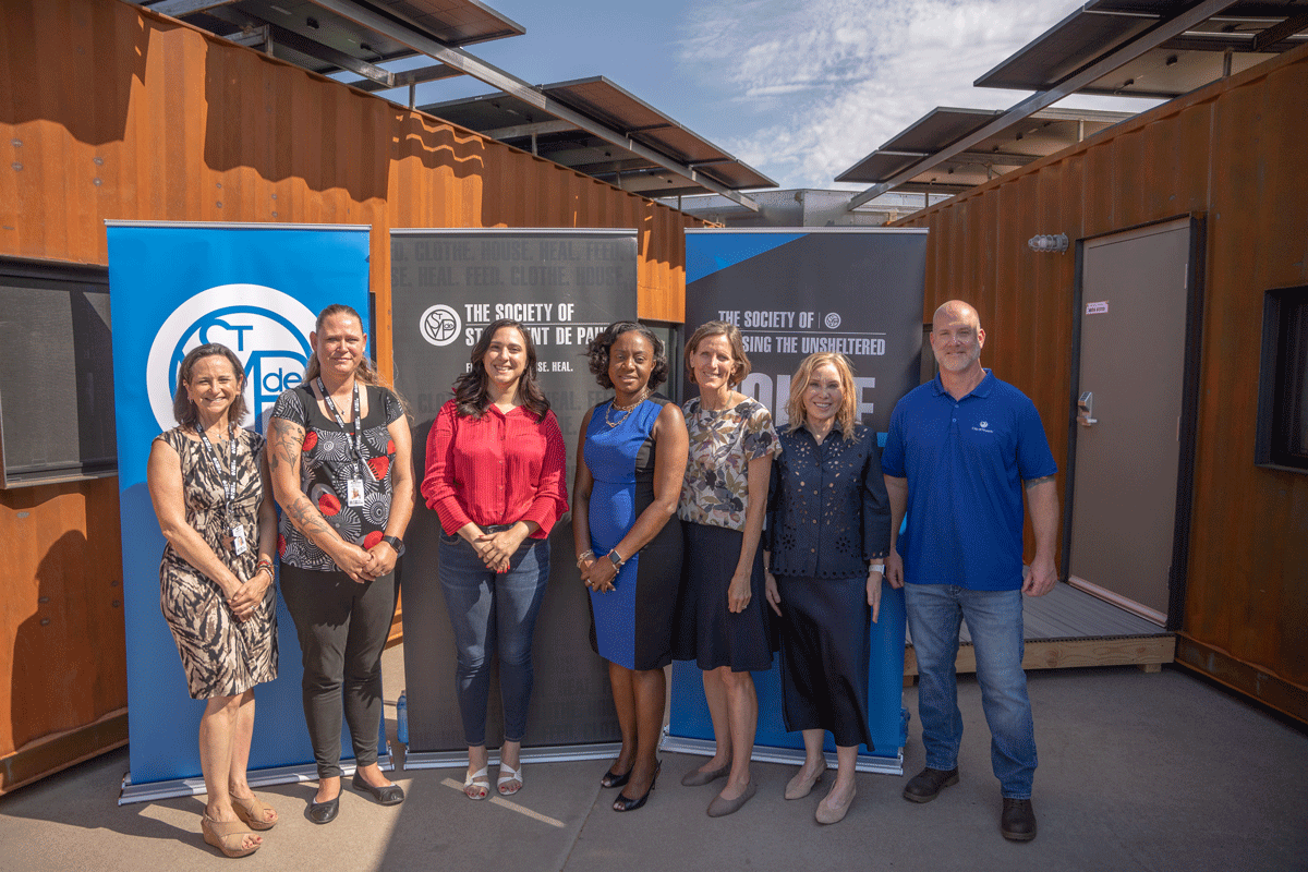 Local officials Vice Mayor Yassamin Ansari (center in red) and District 8 Councilwoman Kesha Hodge Washington (center in blue) also attended to show their support alongside (from right) Phoenix Deputy Director Scott Hall, Steel+Spark partner Kathleen Santin and SVdP CEO Shannon Clancy. From left are SVdP Chief Program Officer Jessica Berg and Washington Street Shelter Manager Jennifer Olsen.