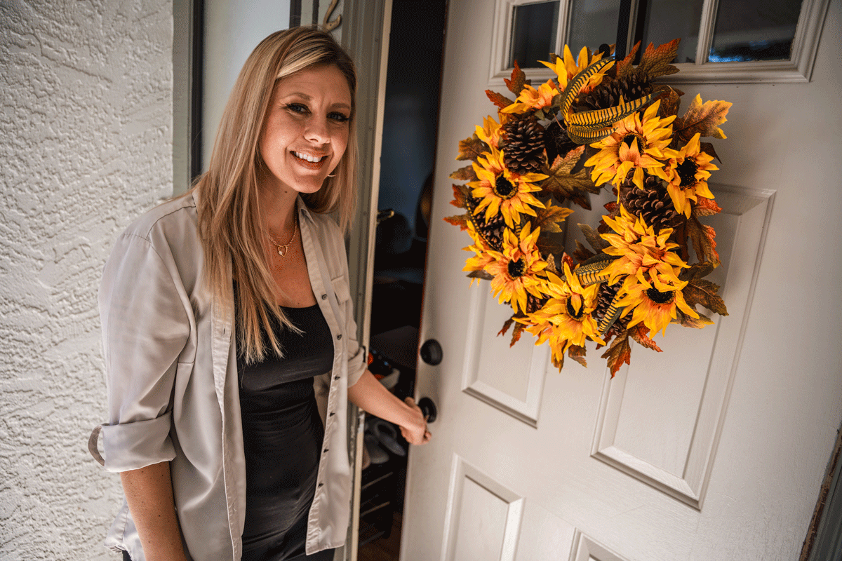 Andrea opening the door to her apartment.