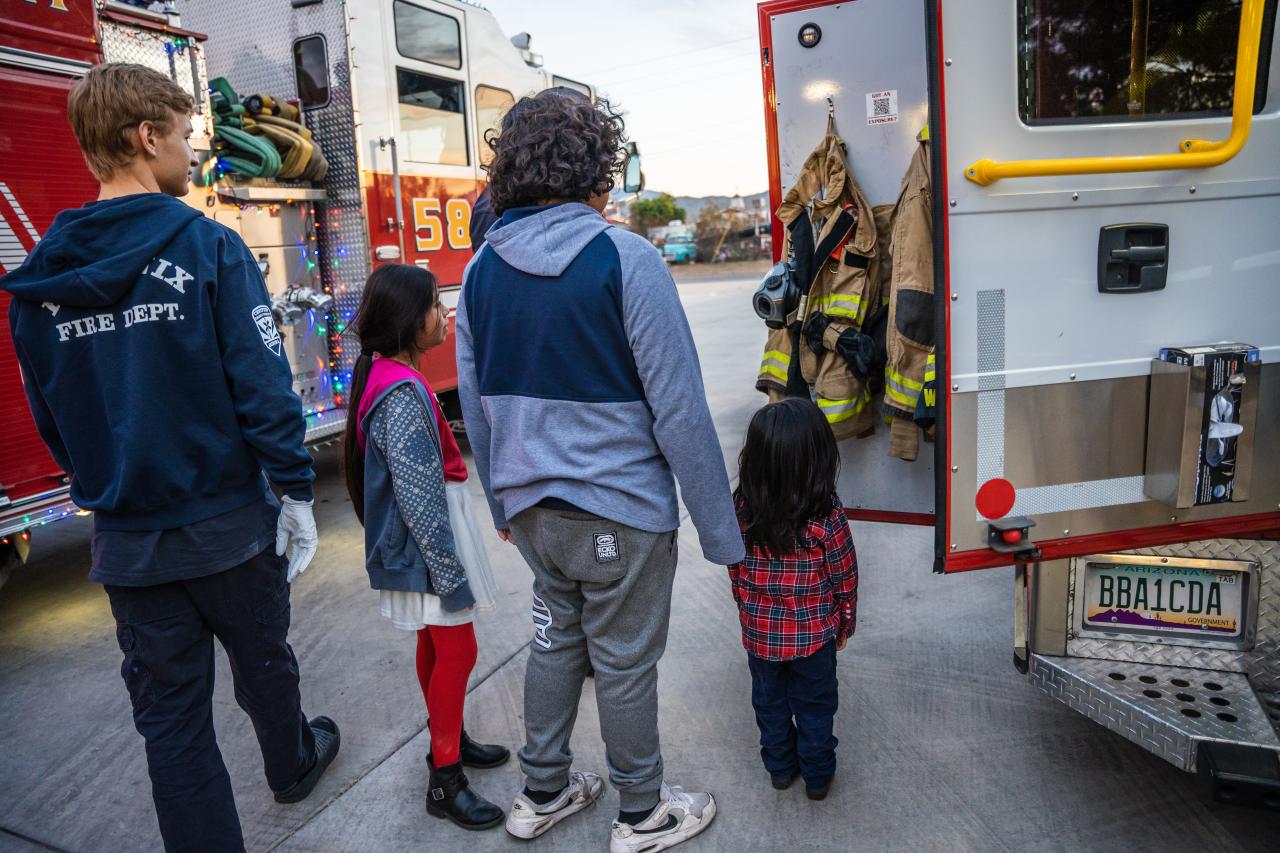 One of the fire fighters shows the kids around a fire truck.