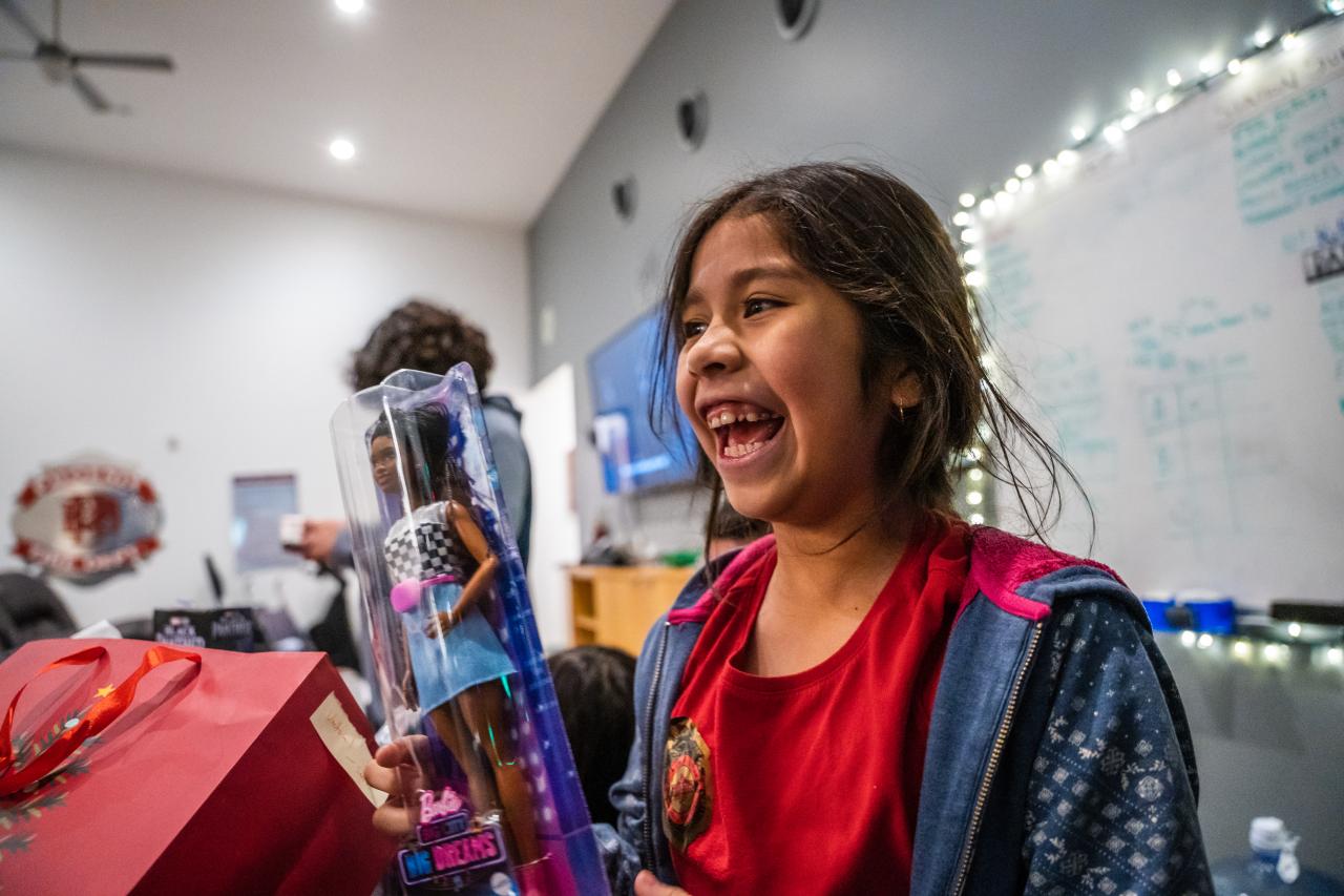 Victoria grins at her new Barbie doll.