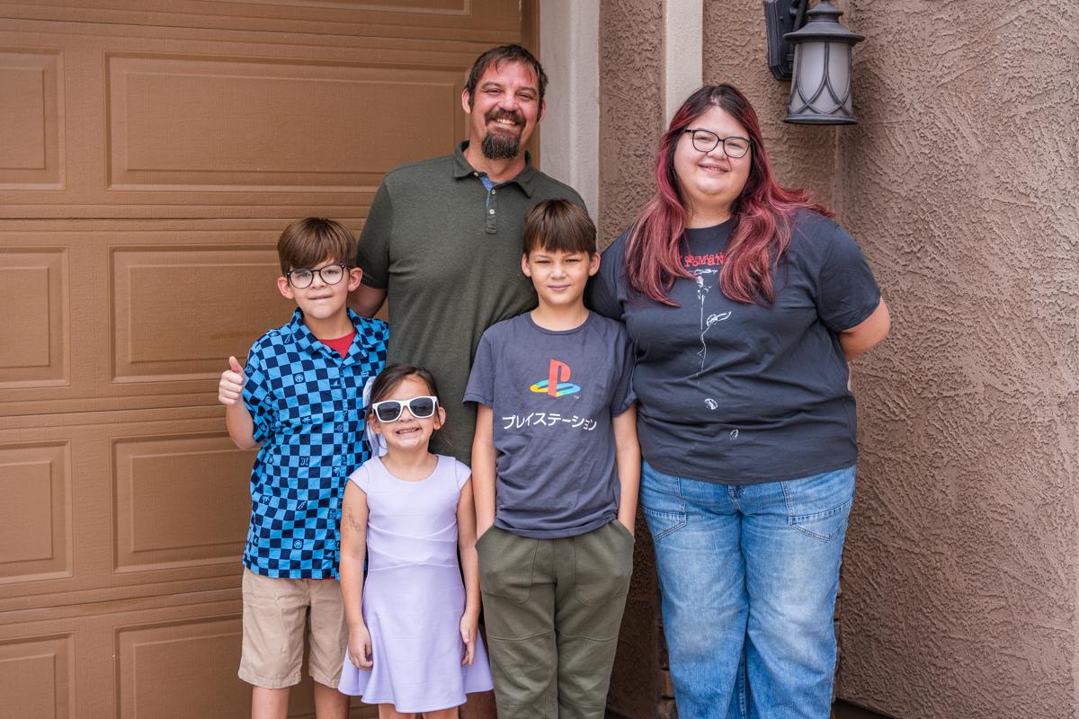 The Lorente family stands outside their home.