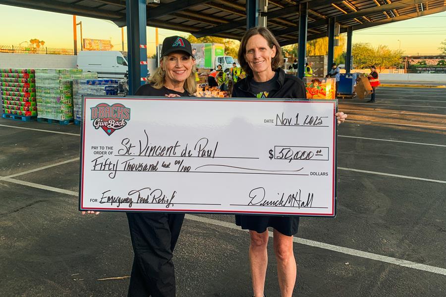 A representative from The Arizona Diamondbacks gives SVdP's Rob and Melanie Walton endowed CEO Shannon Clancy a check.