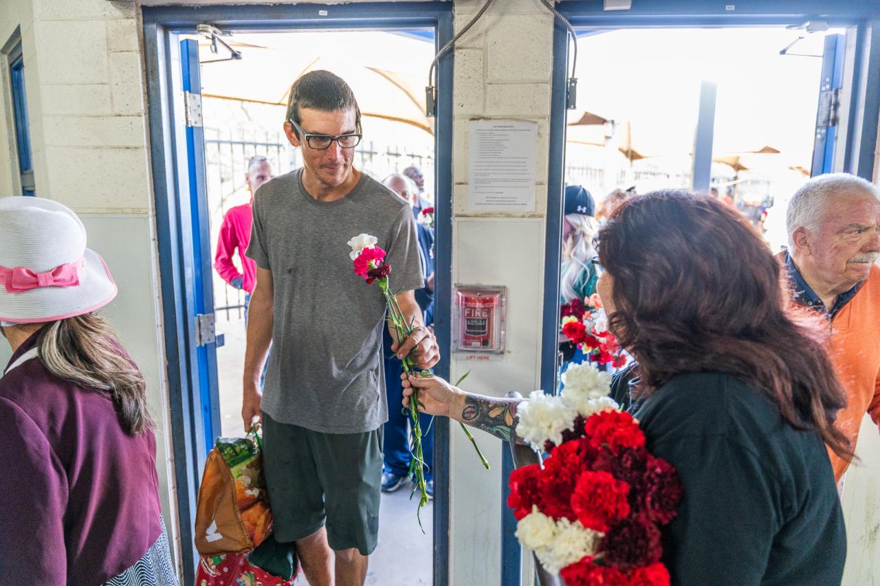 A volunteer hands a guest a flower at the Phoenix Dining Room.