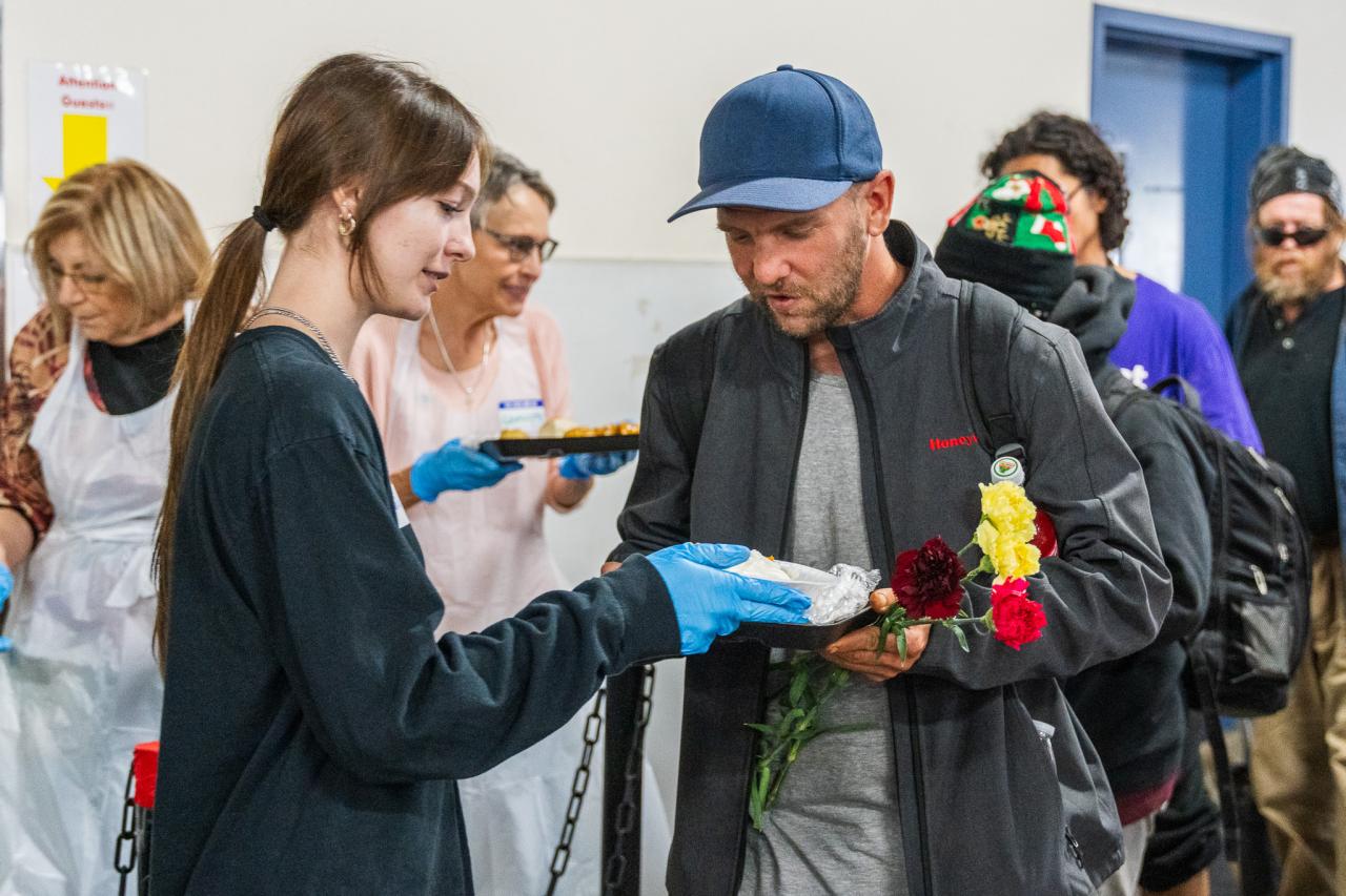 A volunteer hands a guest a plate at the Phoenix Dining Room.