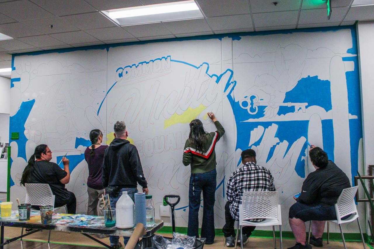 Jesse leads a group painting the mural.