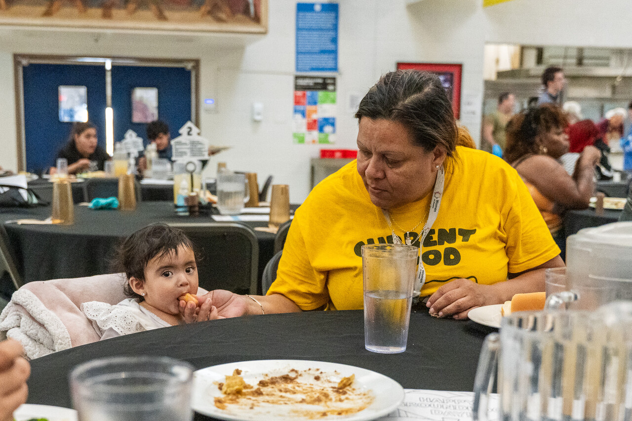 Adriana feeds her granddaughter at FEM.