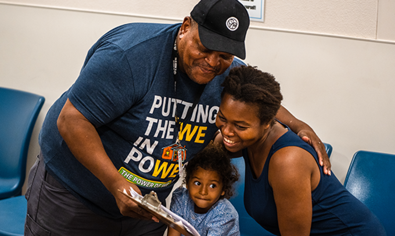 Resource Center campaign header Man putting his arm around a woman and child in the resource center