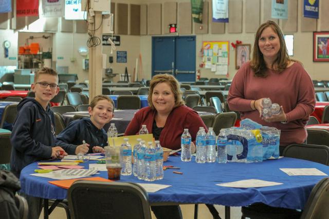 Two adult women and two kids at a table doing crafts