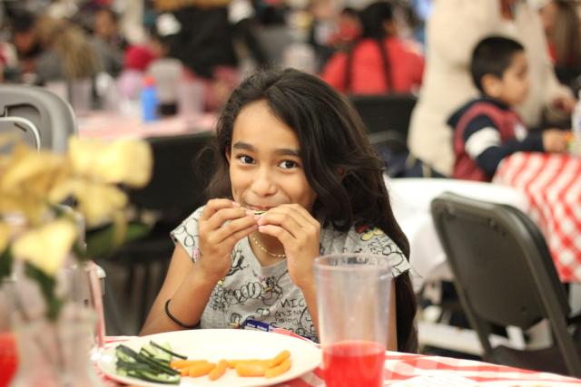 Girl eating food in St. Vincent de Paul's Family Dining Room