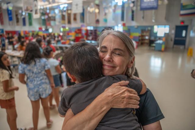 Woman hugging a young boy in the SVdP family dining room